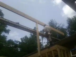 Carpenter setting a ridge beam over a new addition frame — Ice Dam Removal by Roofing Brothers in Brice