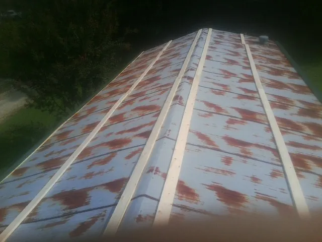 Rusted metal roof panels with new wood purlins before replacement — Storm Damage Roof Repair in Brice by Roofing Brothers