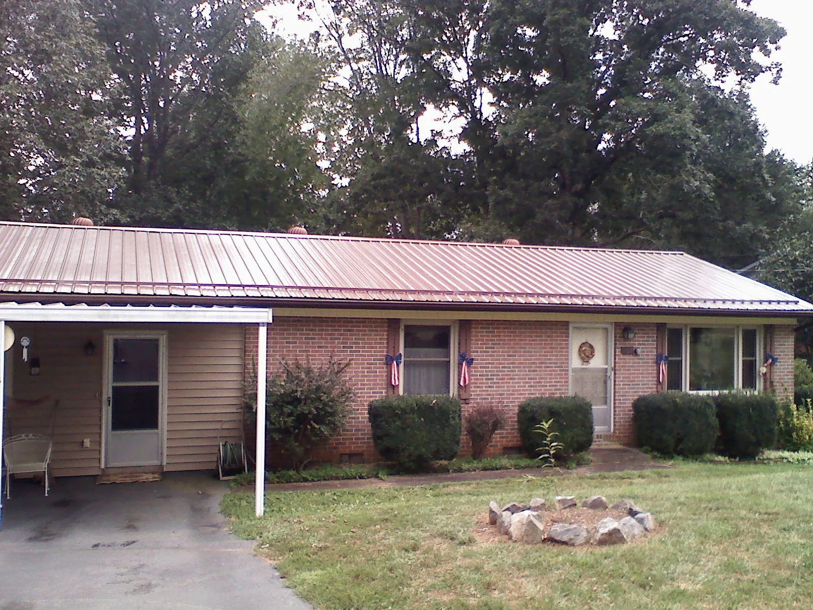Bronze metal roof and carport on a brick ranch home — Roof Repair work by our crew in Brice