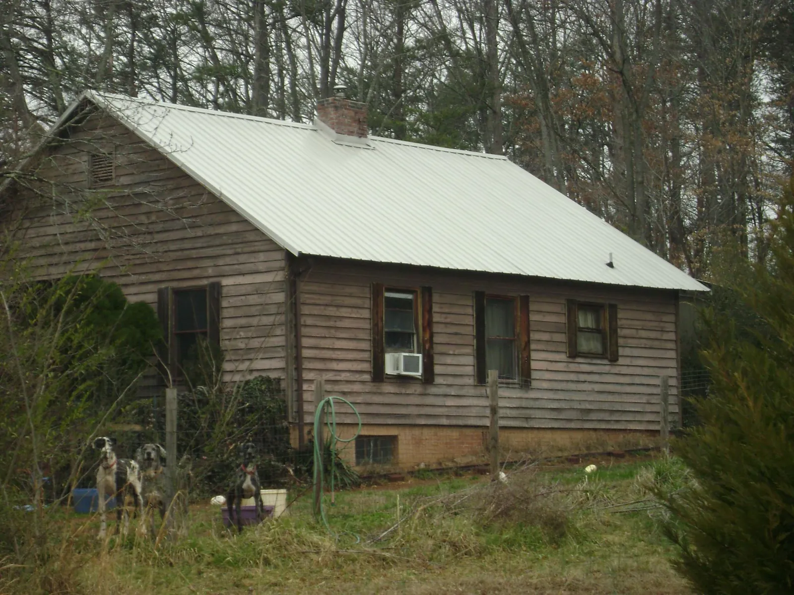White metal roof on an old wood sided farmhouse, from a Metal Roof Installation job in Brice